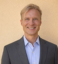 Jeffrey Lamie headshot. White male with blonde hair wearing a grey suitcoat and blue dress shirt.