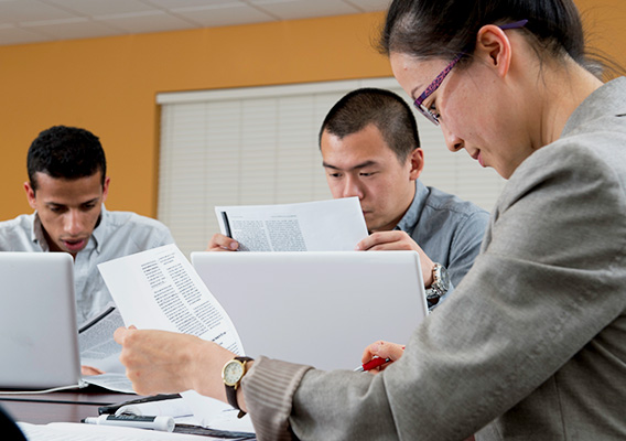 3 Graduate students review their notes at the Hudson Center
