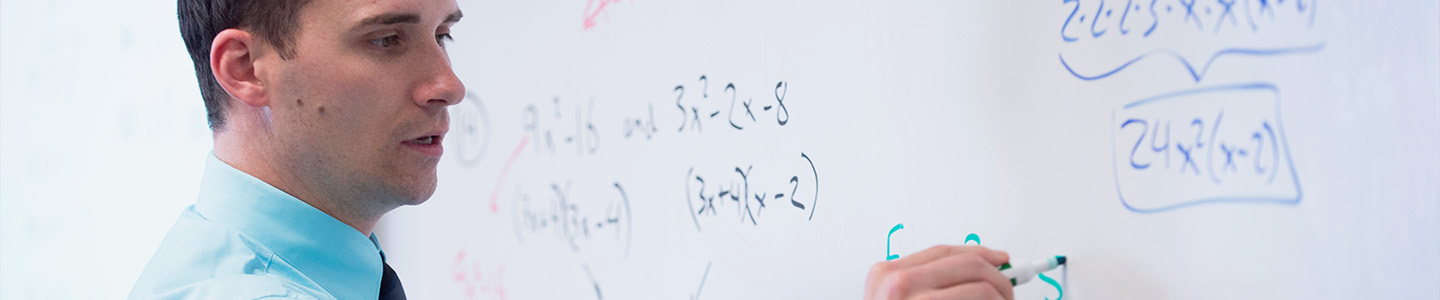 Mathematics Graduate student solves a problem on a whiteboard