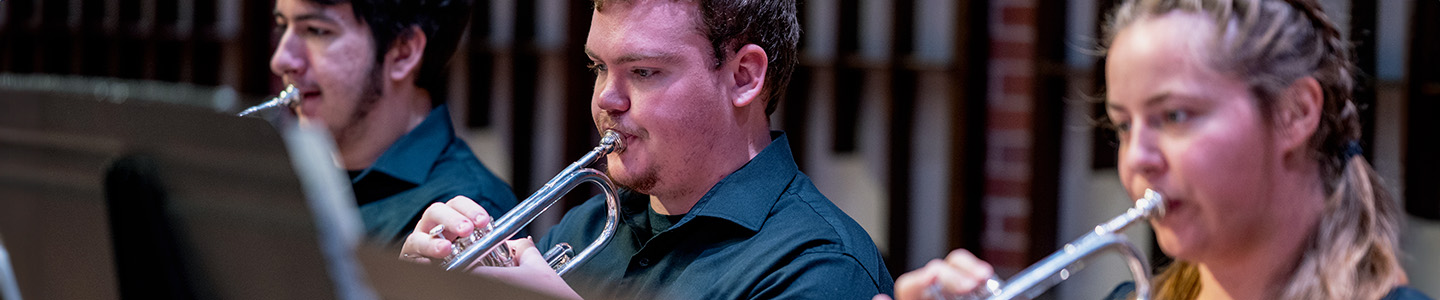 Three students play the trumpet during a musical performance in Abbott Concert Hall