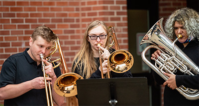 Three Music students playing brass instruments