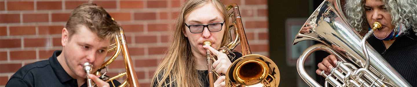 Three Music students playing brass instruments