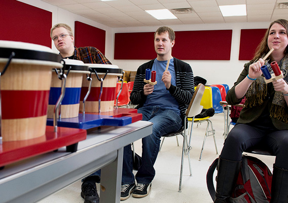 Three students play instruments during a Musical Education class