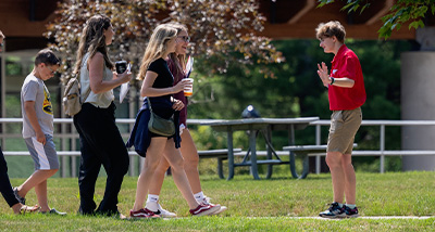 A student tour guide speaks to a group of people during a campus tour