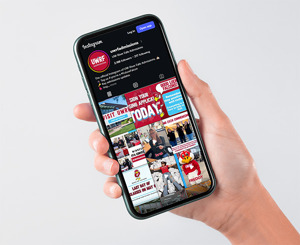 A hand holding an iPhone with the UWRF Admissions instagram account on screen