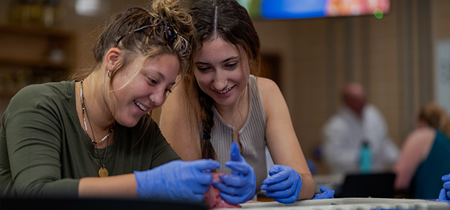 Two female students conduct a science experiment in a campus lab class