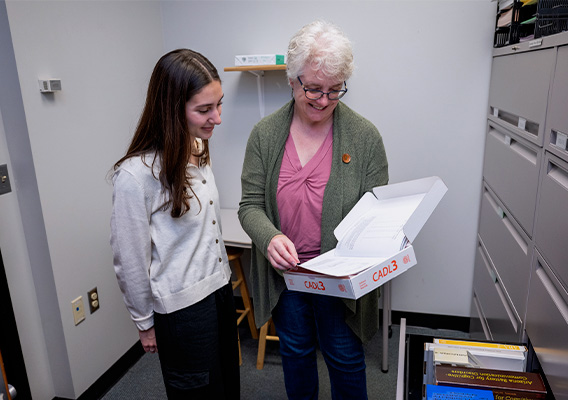 A professor and student review content in a booklet