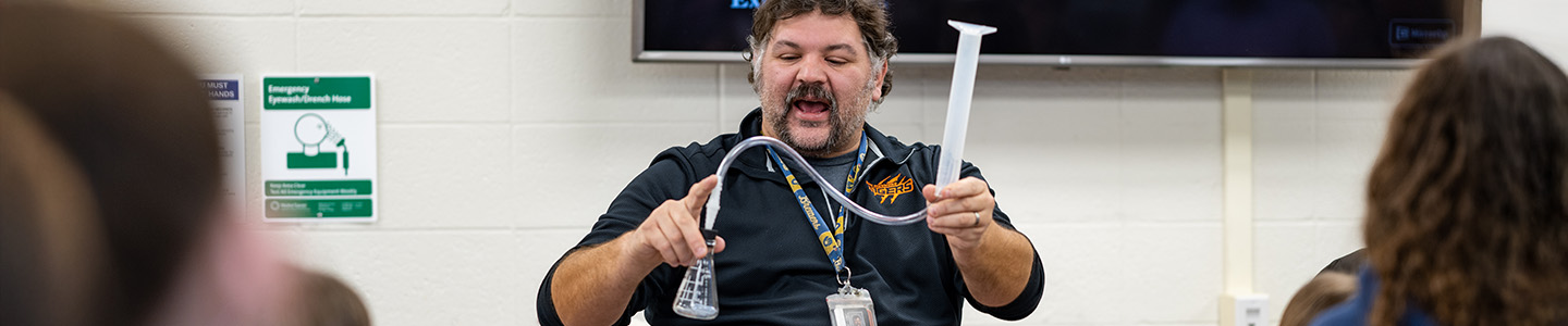 Terry, UWRF Physics Education Graduate, demonstrates a physics activity to high school students 