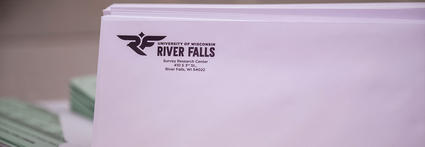 A stack of white envelopes with "UWRF Survey Research Center" sit on a table