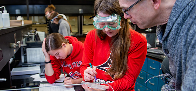 Professor Follensbee helps a student during a Chemistry lab