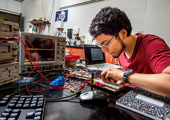 Physics student works on wiring a circuit board