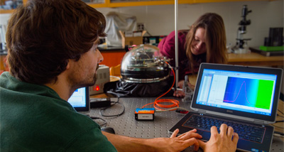 Physics student analyzing data on their laptop