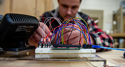 Engineering student wiring a practice circuit board