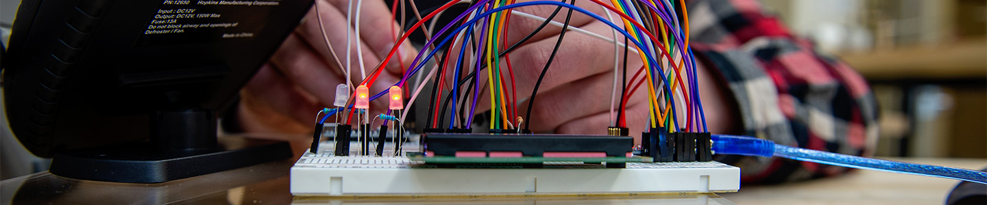 Engineering student wiring a practice circuit board