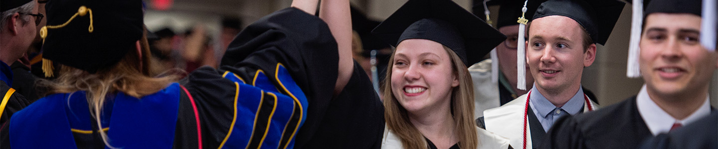 Pre-Law student gives high-five to professor during graduation ceremony