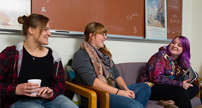 Three Psychology students discuss coursework during class
