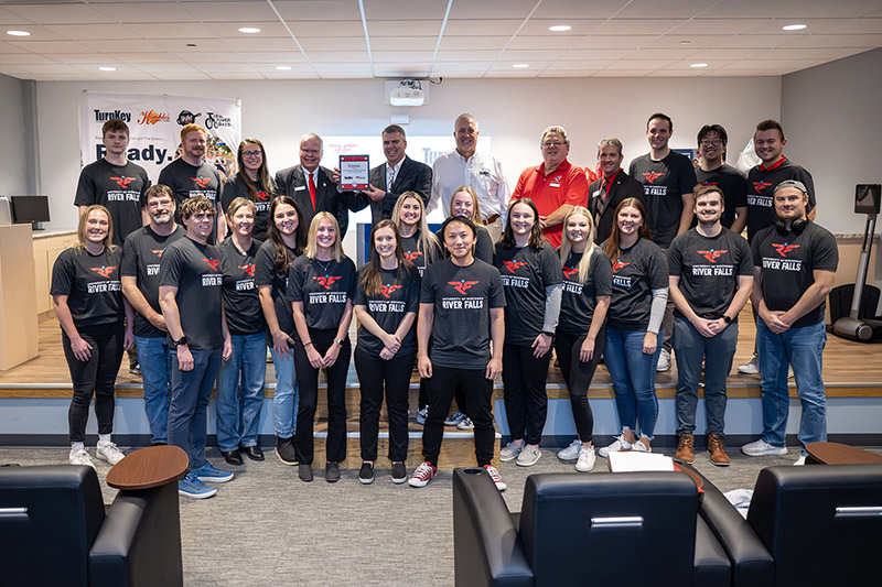 Turnkey Corrections staff pose with officials from UWRF and UWs