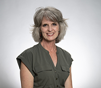 Rhonda Petree headshot. A white woman with grey hair wearing a dark green top.