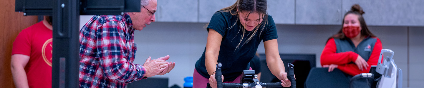 A professor cheers on a student taking part in an exercise study