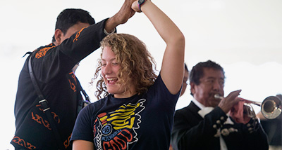 Student dances with a band member during the Year of Mexico kickoff event