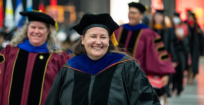 Faculty walk in their regalia at Commencement
