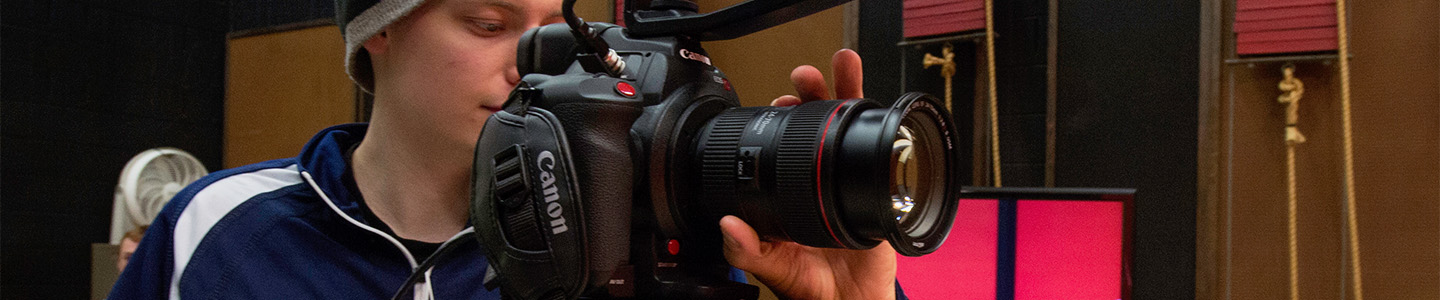 Stage and Screen Arts student looks through the lens of a camera during class