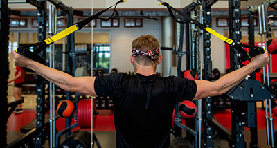 Strength and Conditioning Graduate student lifts weights in the campus gym