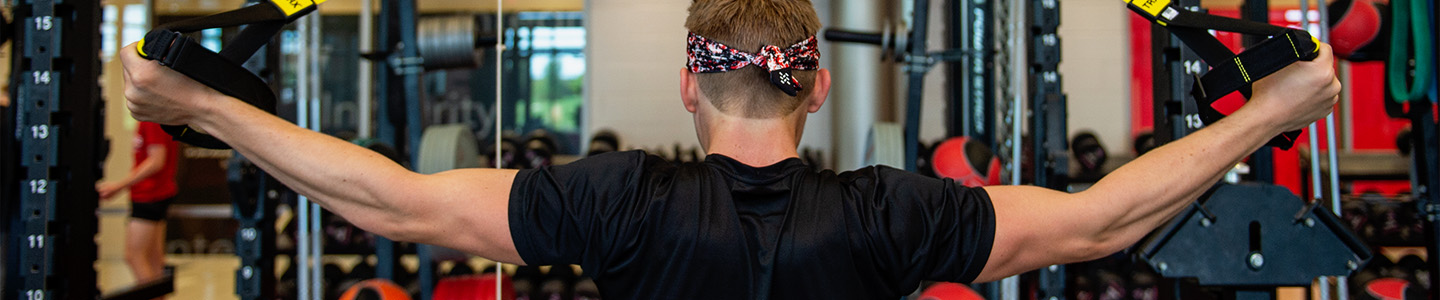 Strength and Conditioning Graduate student lifts weights in the campus gym