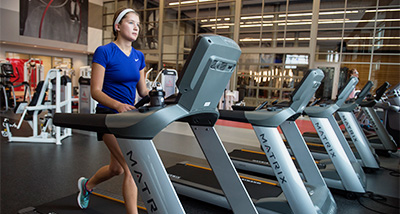 A student jogs on a treadmill in the Falcon Center