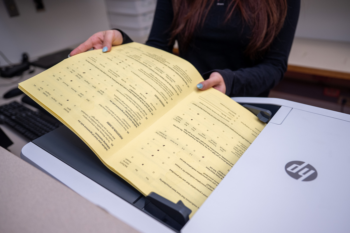 a person's hands are holding paper's coming off a printer