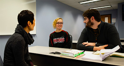 Two Students converse with their professor during class