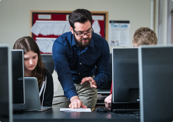 A professor helping a student in a computer lab