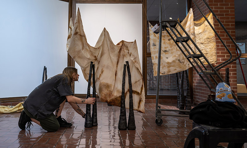 a person works to set up an art display in a gallery