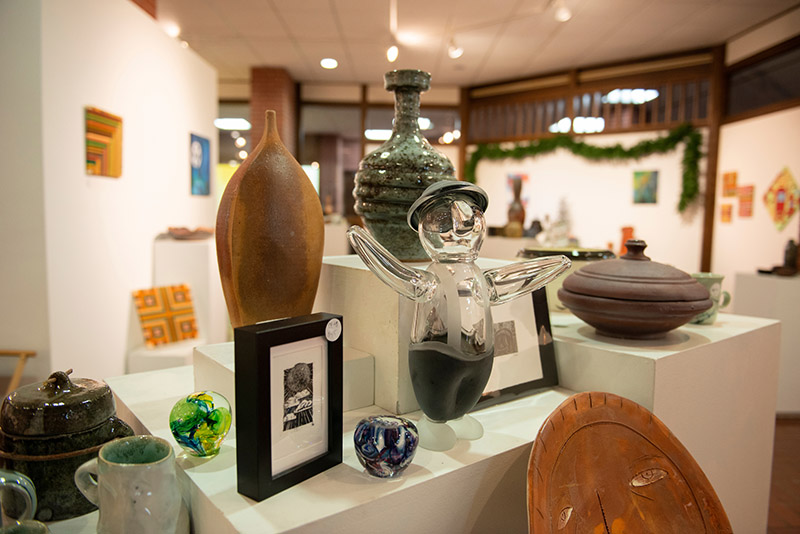 handmade art items are displayed on a shelf