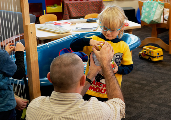 Elementary Education graduate student helps one of their students open a jar