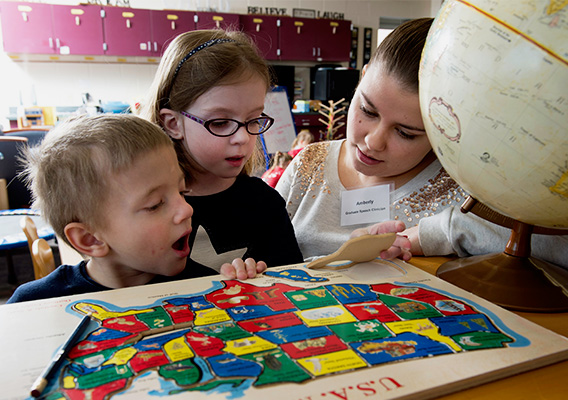 Elementary Education graduate student points to a map of the United States