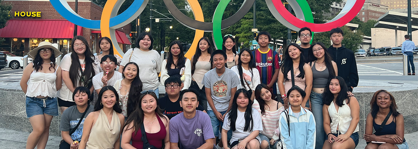 group of high school students posing in front of the Olympic arches in Atlanta, GA
