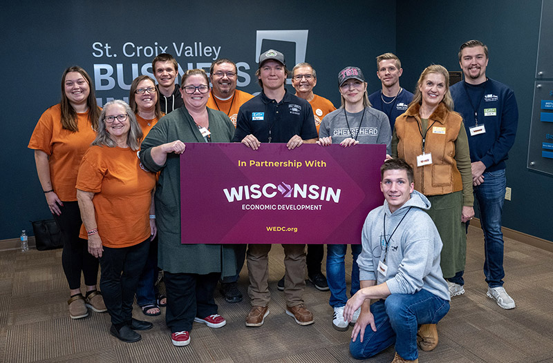 a group of people pose for a photo holding a sign that says "Wisconsin"