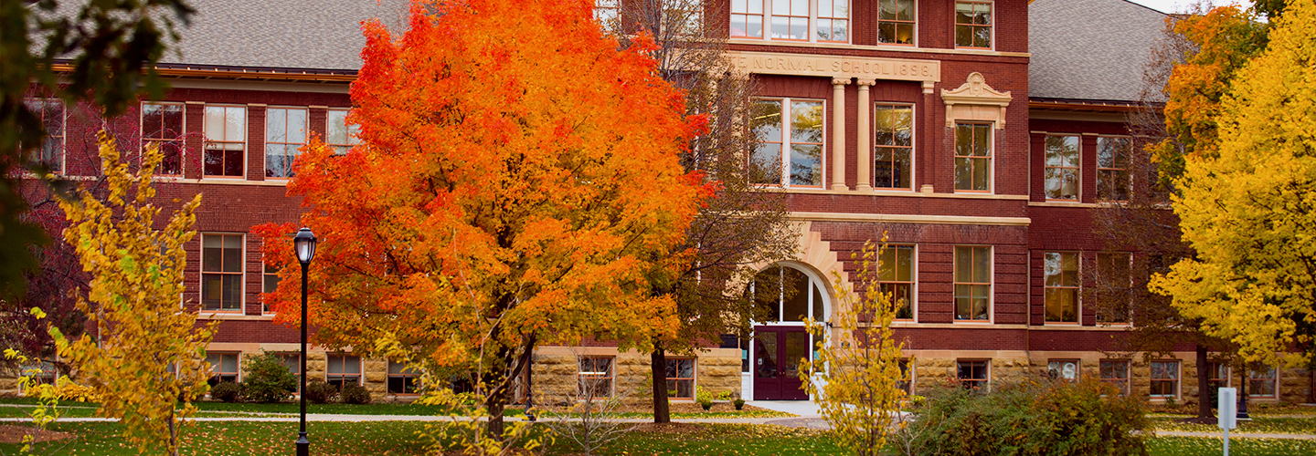 Bright fall colors decorate the trees in front of the entrance of South Hall