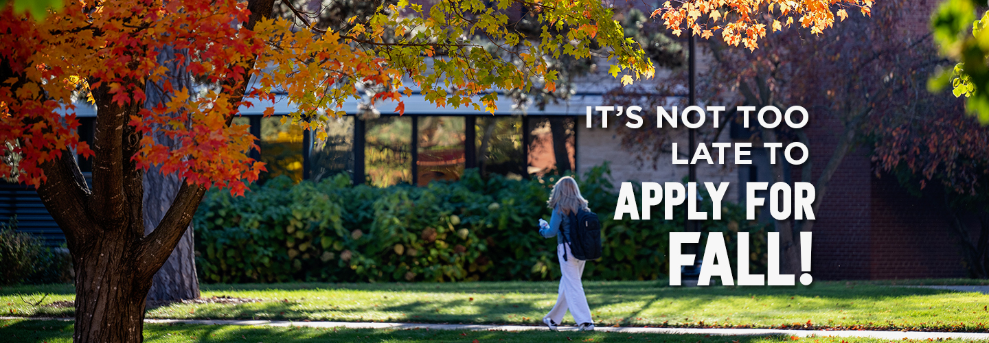 A female student walks on campus near the library